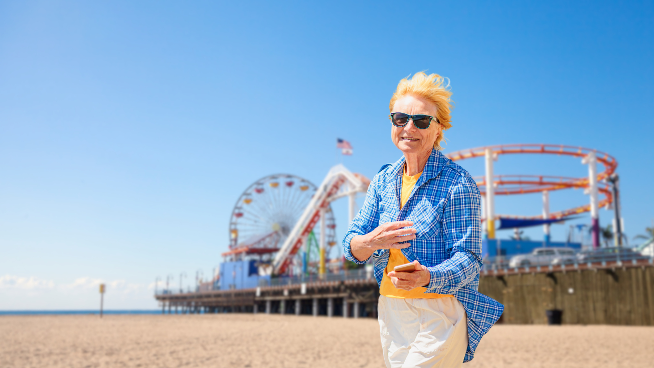Senior woman enjoying a sunny day at Santa Monica Pier, symbolizing vibrant living near Bentley Suites Santa Monica.