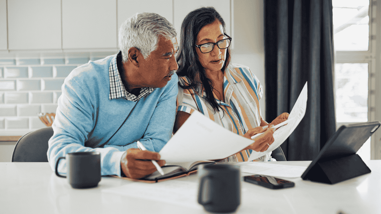 Elderly couple reading documents together, exploring if Medicare cover assisted living expenses